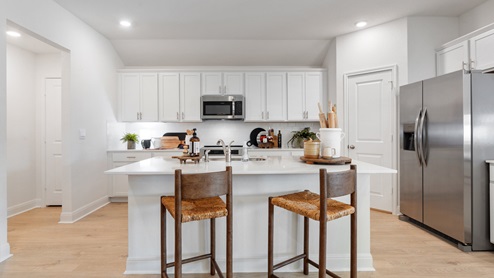 Kitchen with stainless steel appliances and decorative tile backsplash.