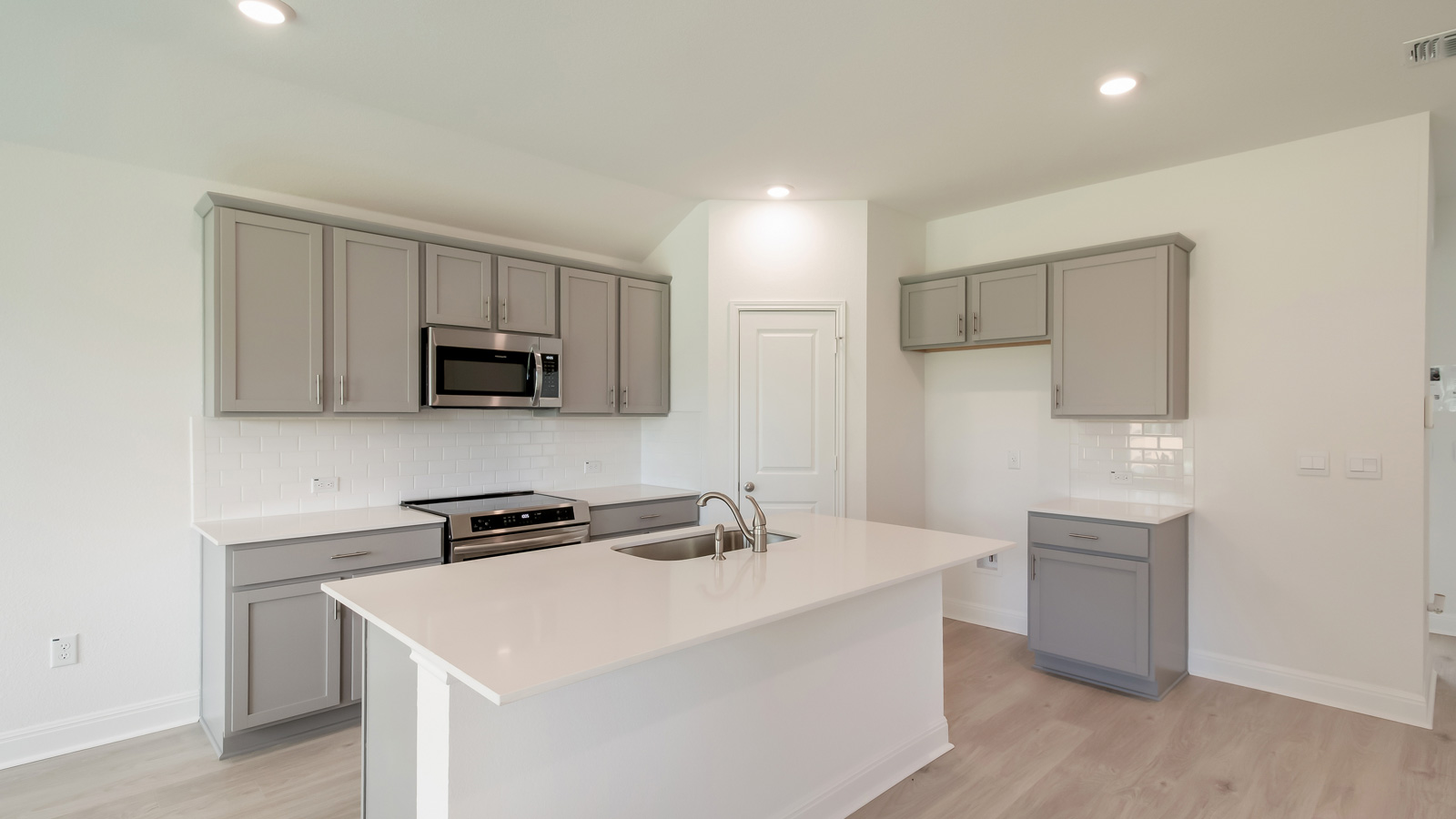 Gourmet kitchen with stainless steel appliances and quartz countertops.