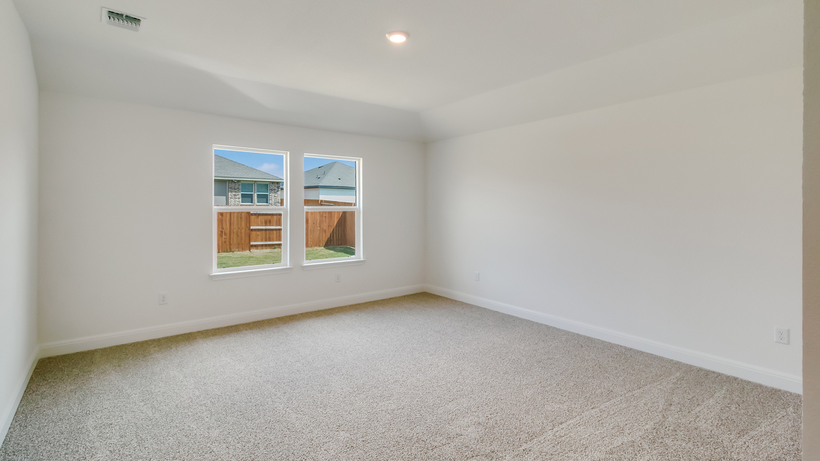 Bedroom 1 with carpeted flooring and large window.