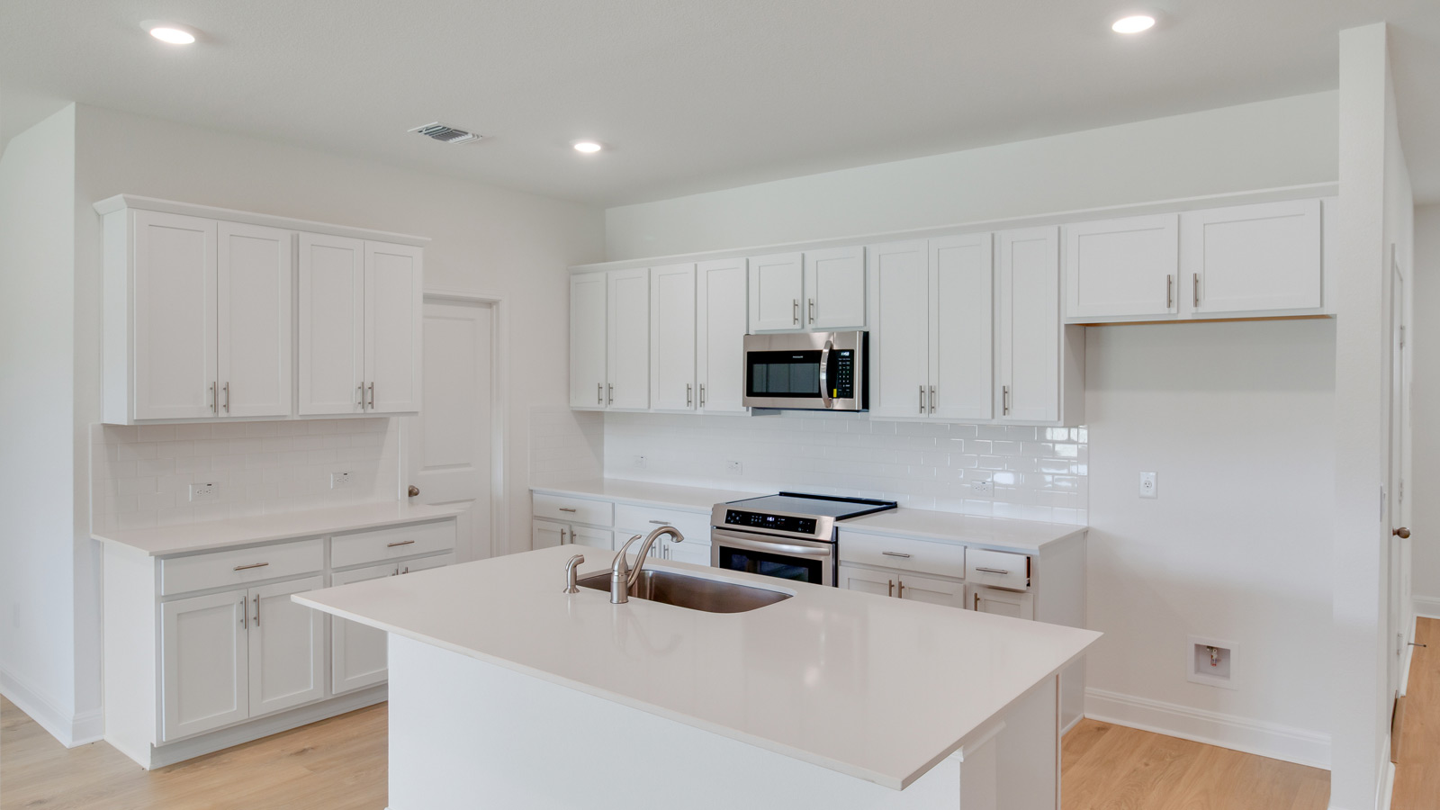 Gourmet kitchen with stainless steel appliances and quartz countertops.