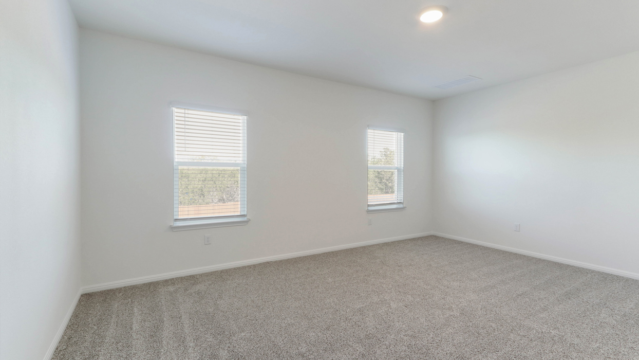Primary bedroom with two windows.
