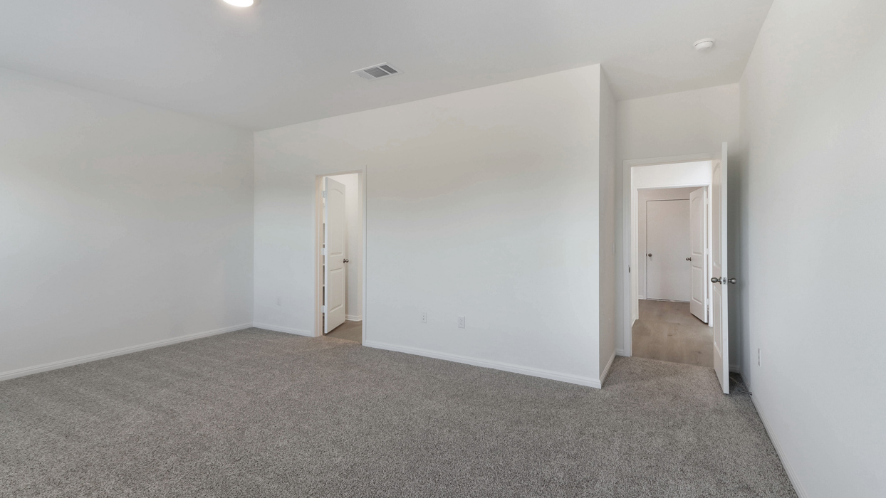 Primary bedroom with carpeted floors and an ensuite bathroom.