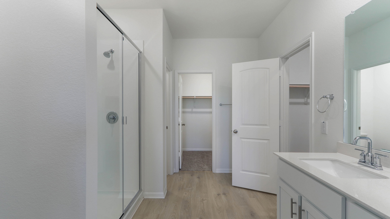 Primary bathroom with a double vanity sink and a walk in shower.