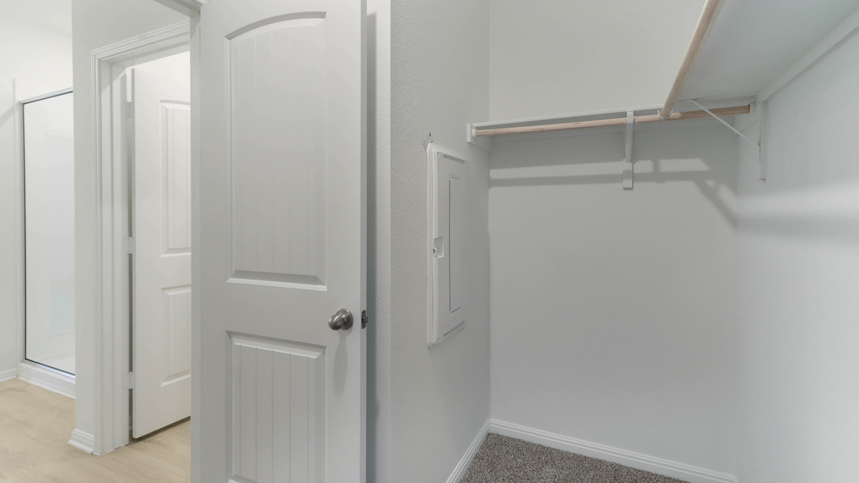 Primary closet with built in clothes racks.
