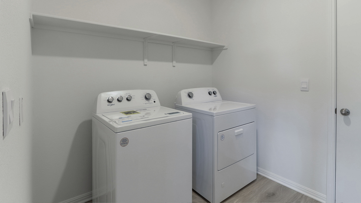 Laundry space with built in storage shelf.