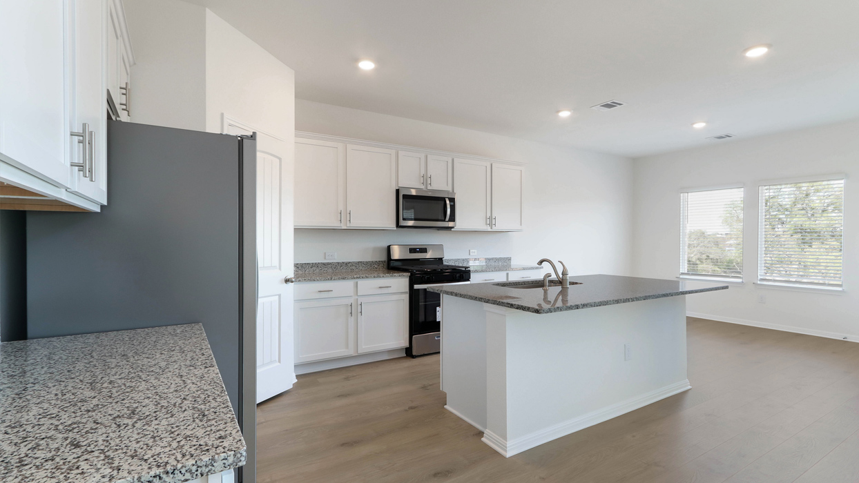 Kitchen with island and granite countertops.