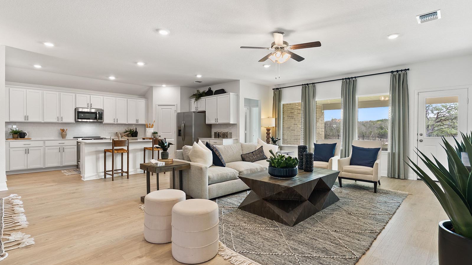 Living room with 3 large windows just off of the kitchen