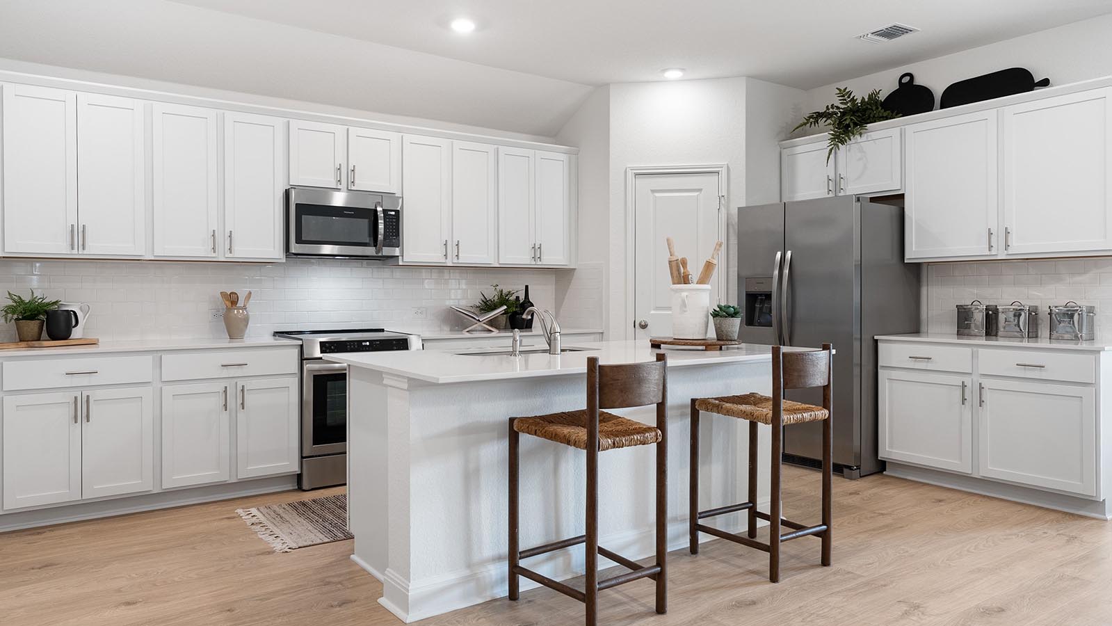 kitchen with white cabinets and island with sink. granite counterrops and stainless steel appliances