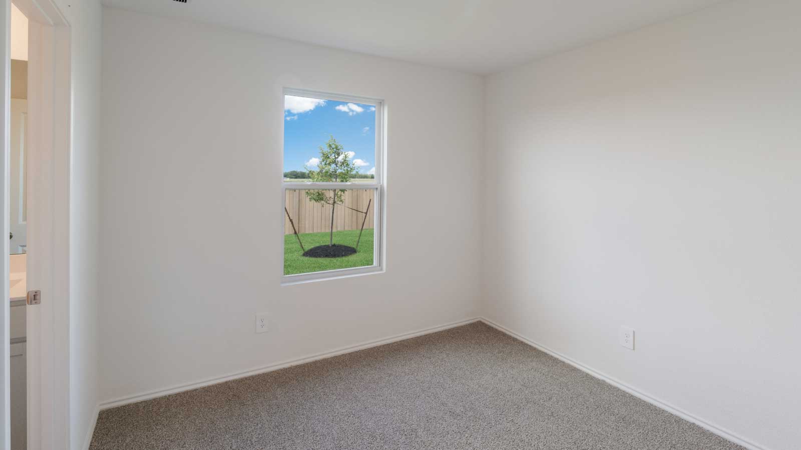 Bedroom with brown carpet, white walls, and a window.