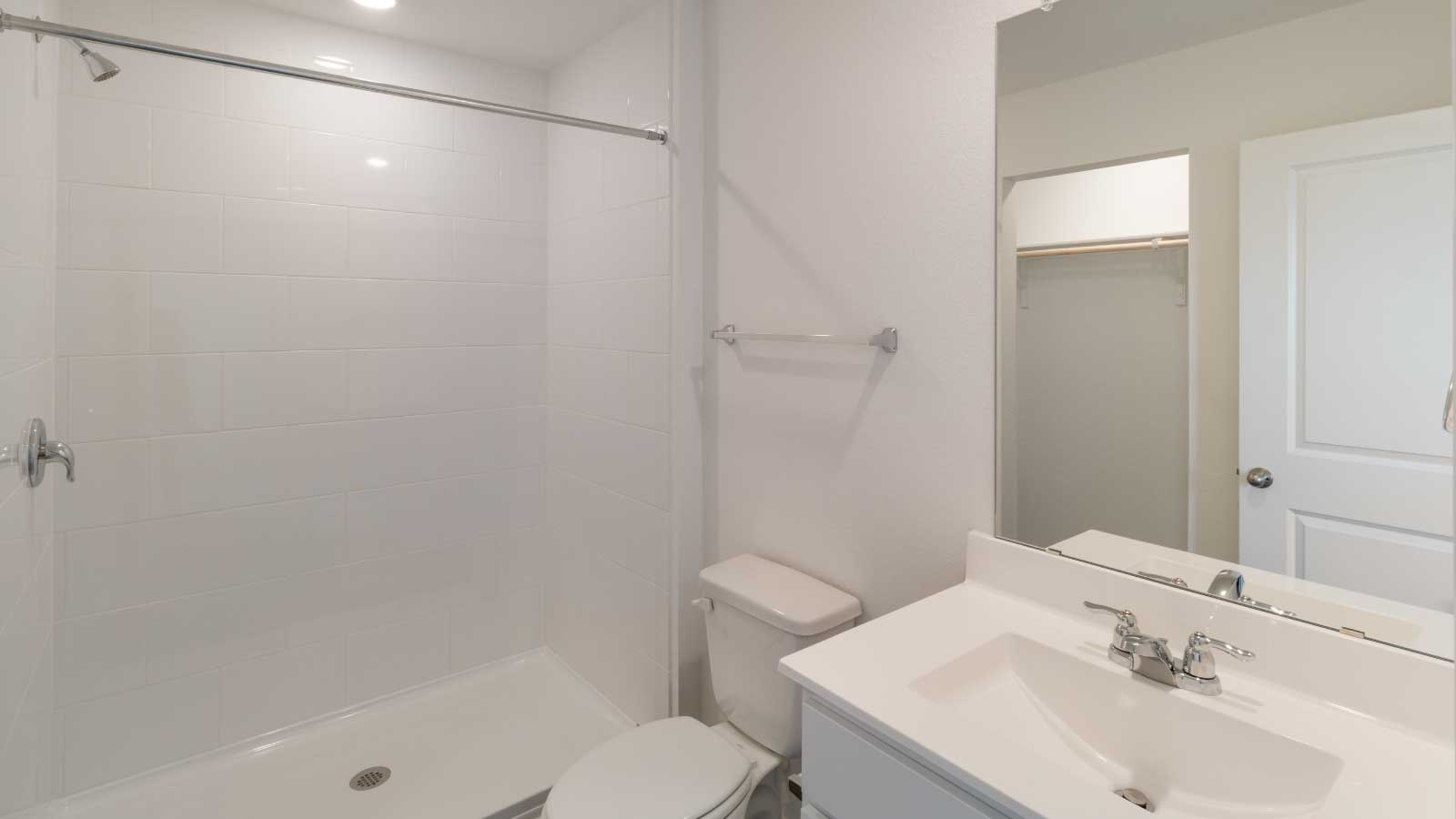 Bathroom with a sink, toilet, and a walk in shower.