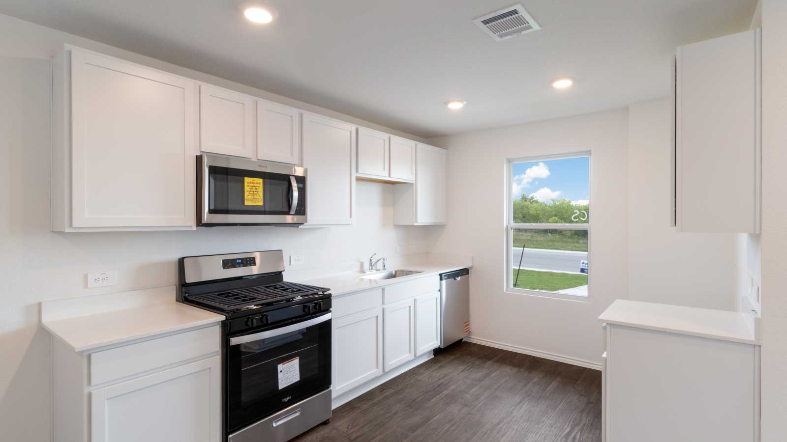 Kitchen featuring white cabinets, stainless steel appliances, and white countertops.