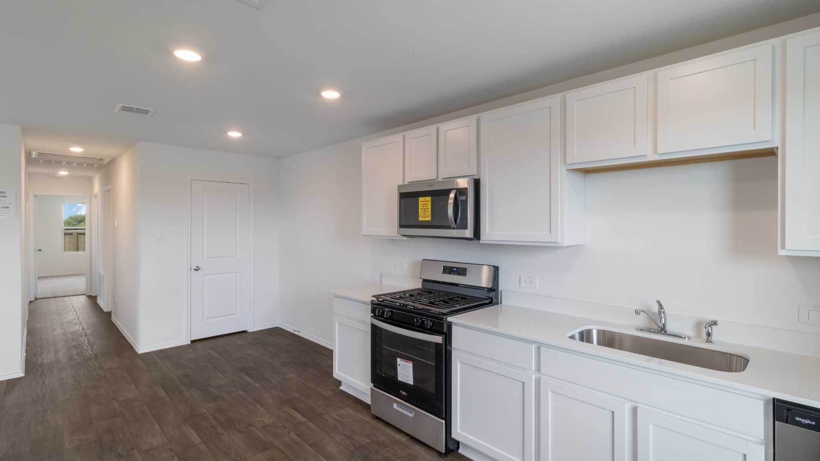 Kitchen featuring white cabinets, stainless steel appliances, and white countertops.