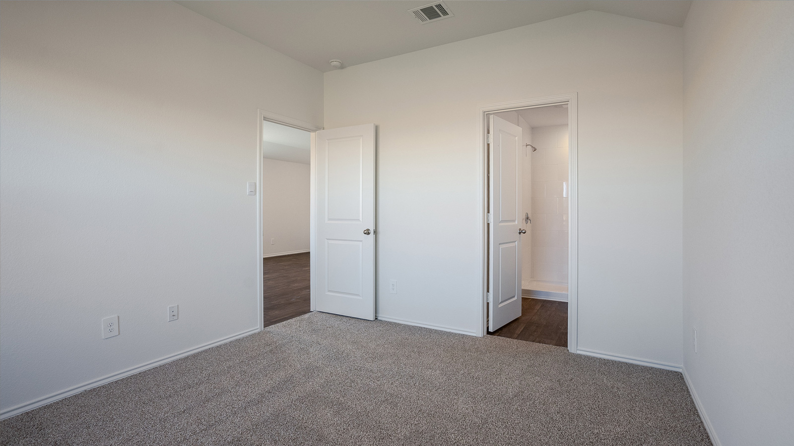 The main bedroom, bedroom 1, with carpeted floors and large window.