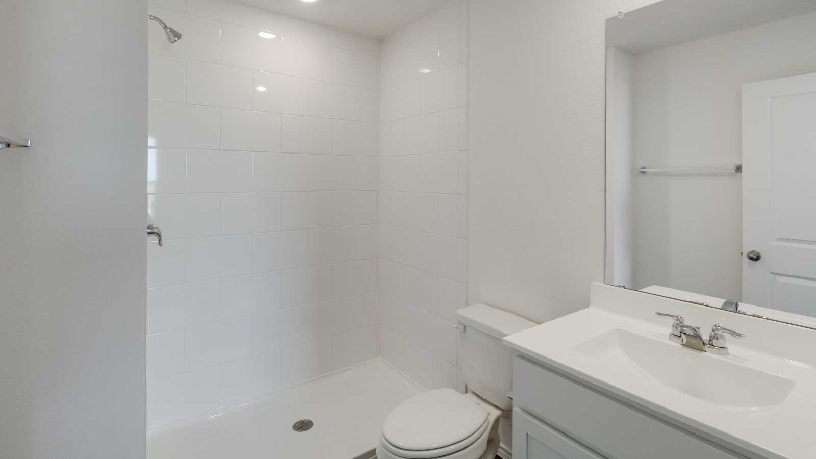 Bathroom with a sink, toilet, and a walk in shower.