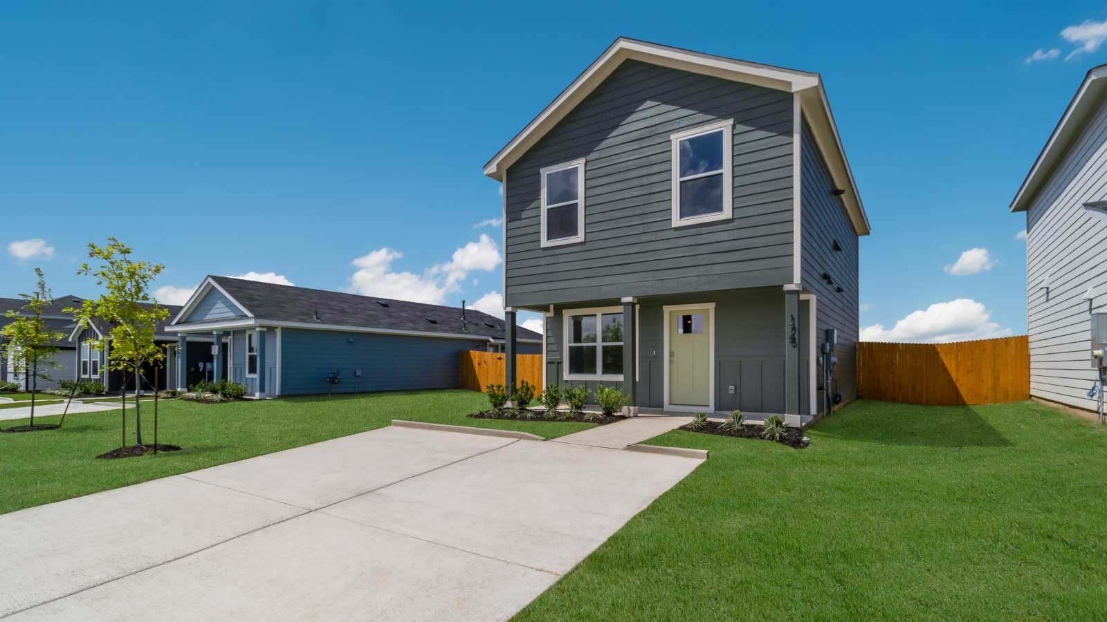 Two story home with light green siding and large windows.