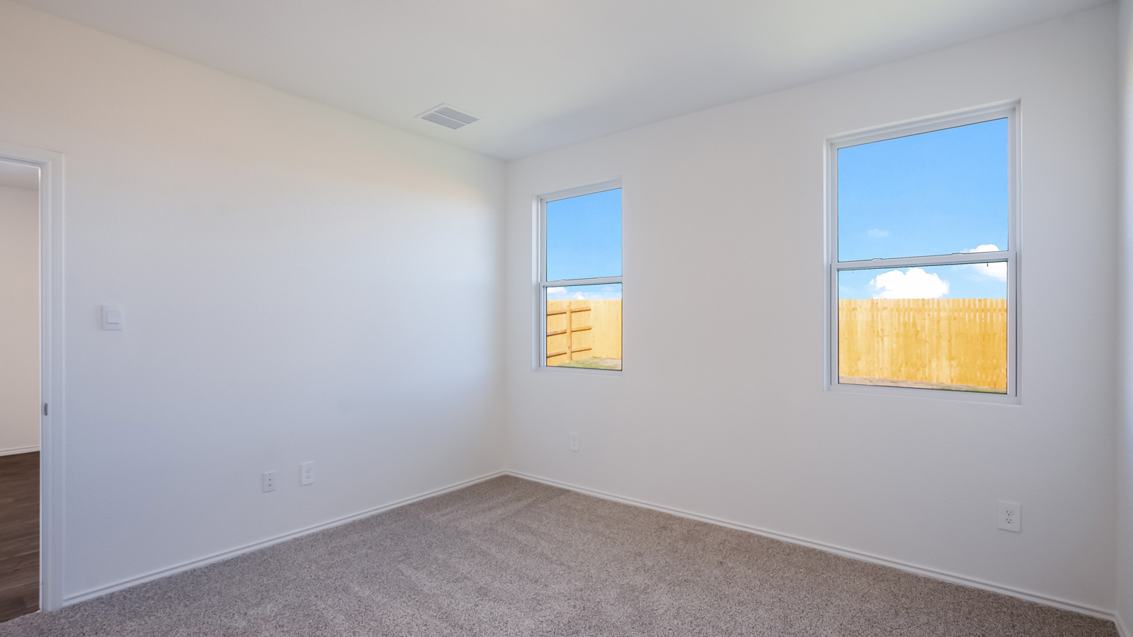 Spacious main bedroom, bedroom 1, with two large windows.