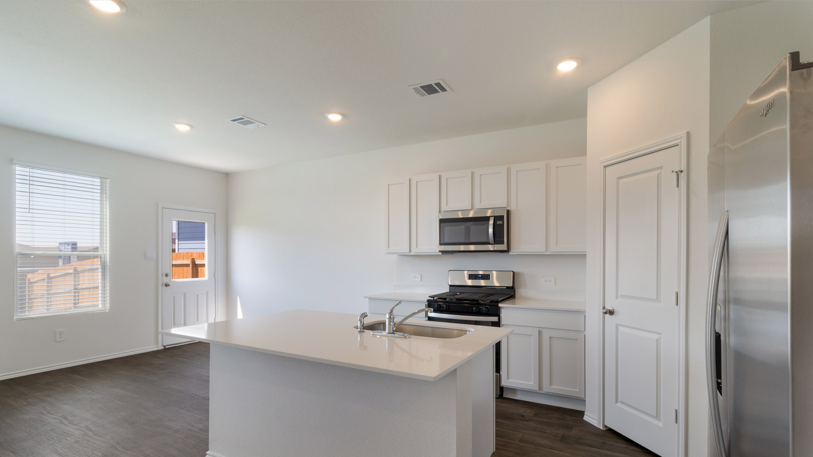 Central kitchen island with sink, seating, and prep zones anchoring the home's main level