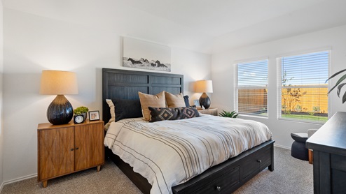 The main bedroom, bedroom 1, with large windows and carpeted floors.