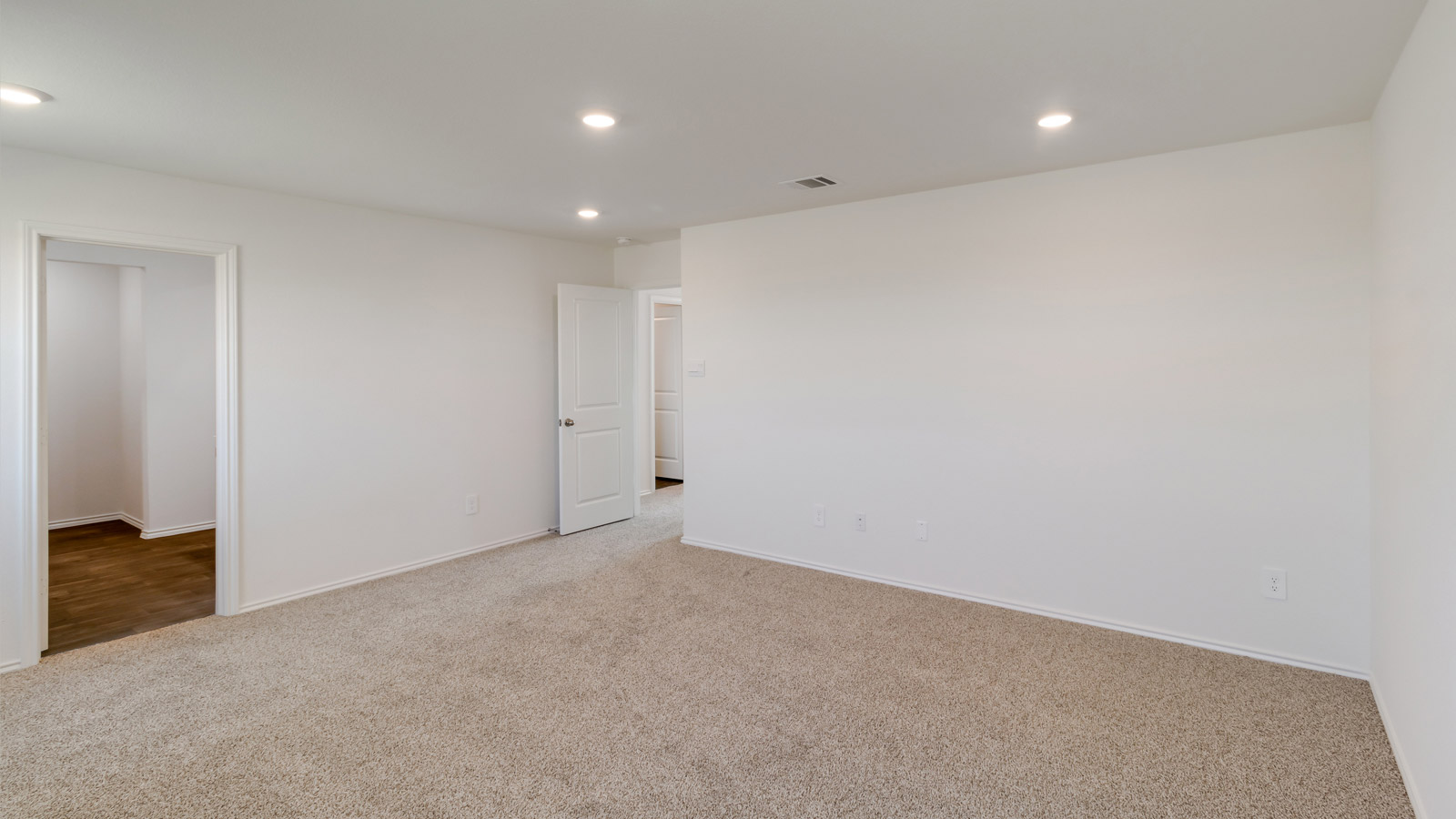 Alternate primary bedroom angle highlighting window light and restful design