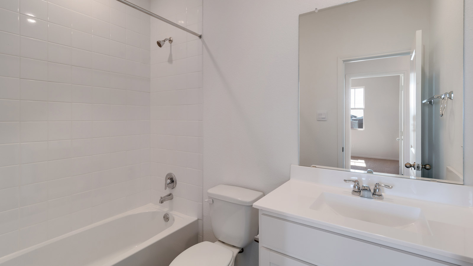 Family full bathroom with vanity, mirror, lighting, cabinetry, and tub-shower combo Marigold by D.R. Horton