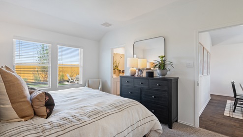 The main bedroom, bedroom 1, with large windows and carpeted floors.