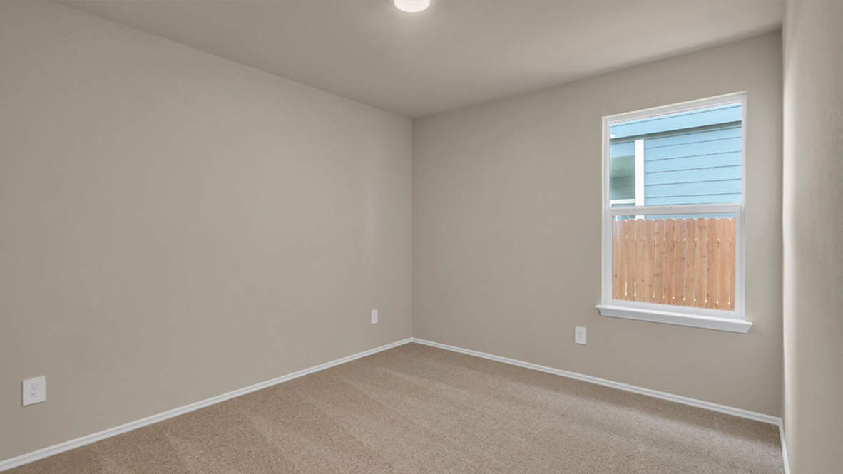 bedroom featuring beige carpet, beige walls and a window