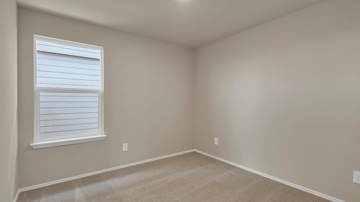 bedroom featuring beige carpet, beige walls and a window