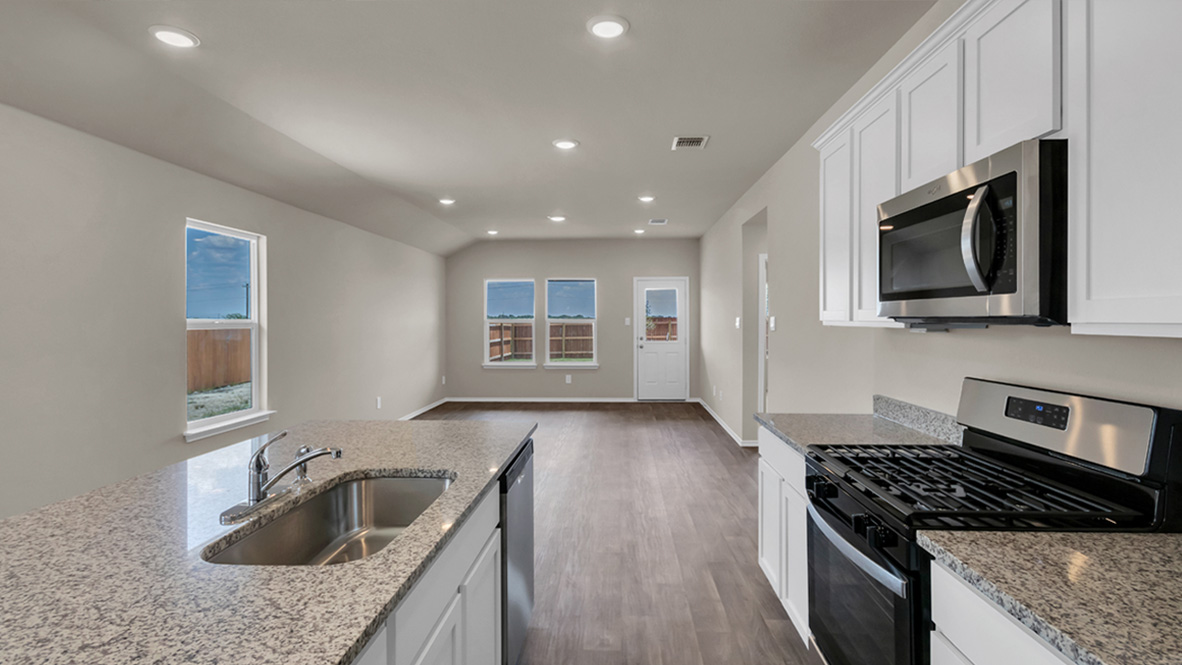 spacious kitchen featuring a large island, white cabinetry and stainless steel appliances