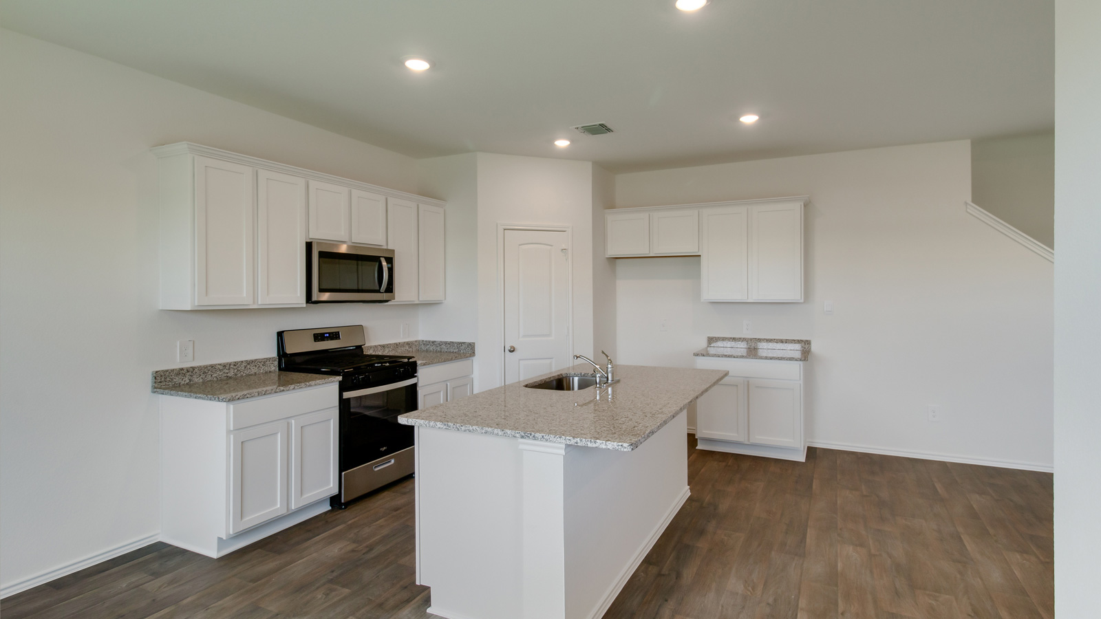 modern kitchen with an island, white cabinetry, and stainless steel appliances