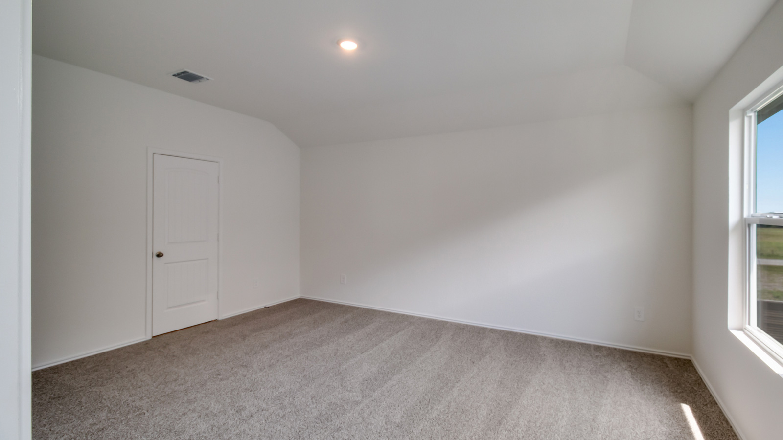 bedroom with beige carpet, white walls and a window