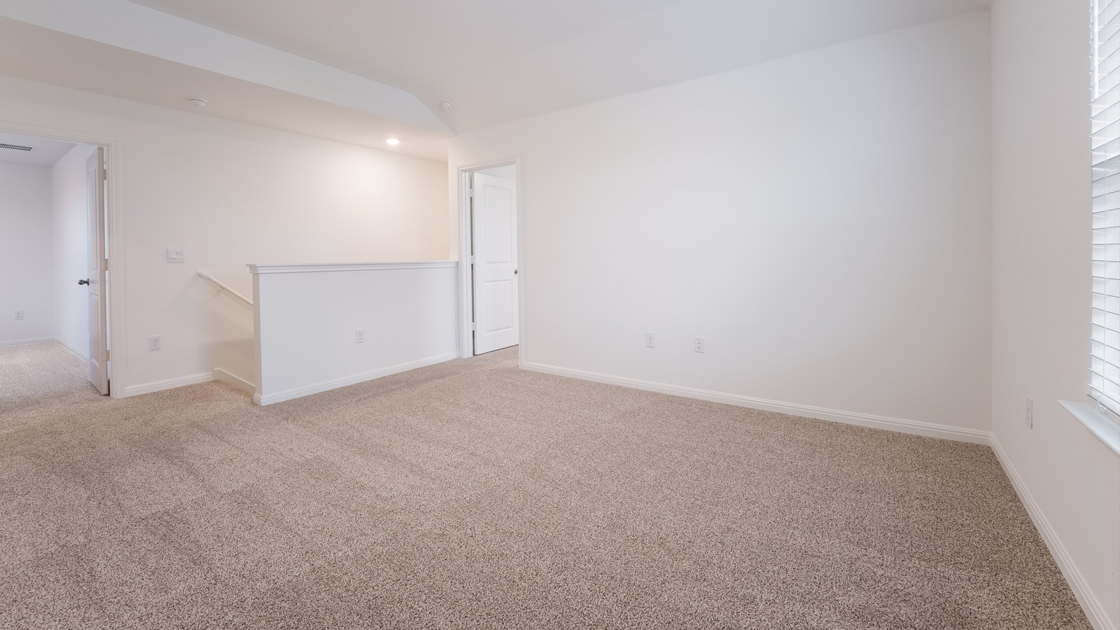 Upstairs loft with carpeted flooring.