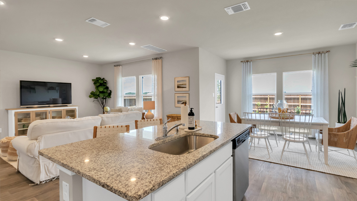 Kitchen and dining area with windows giving views of the backyard.