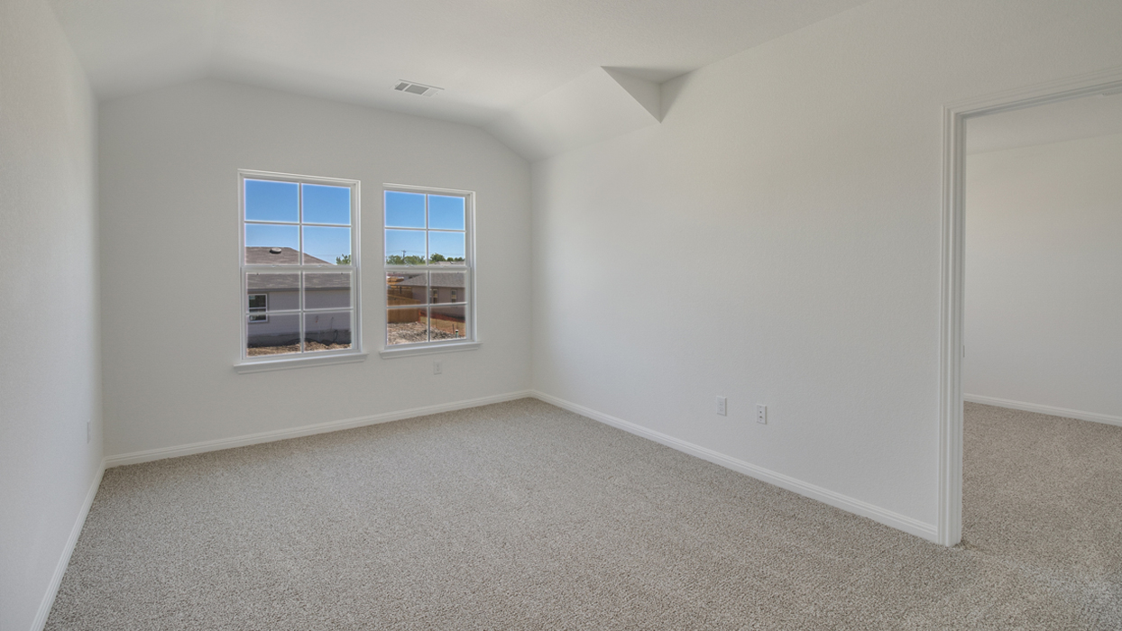 Area at top of stairs with brown carpet, white walls, and two windows.