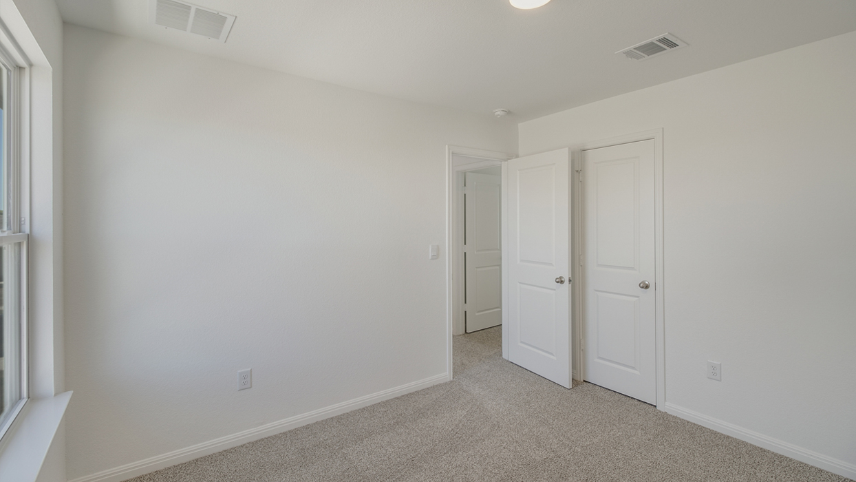 Bedroom with brown carpet, white walls, and a closet.