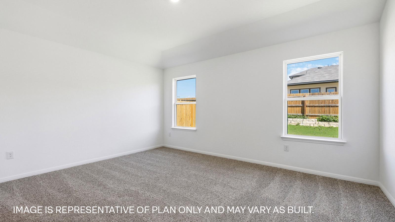 Bedroom 1 with carpeted flooring and two windows.