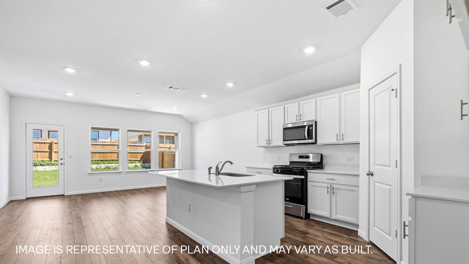 Beautiful kitchen and living area with windows that let in natural light.