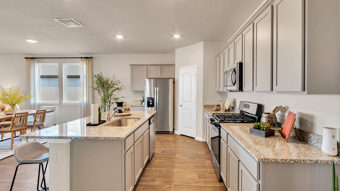 spacious kitchen featuring light grey cabinetry, large island and stainless steel appliances