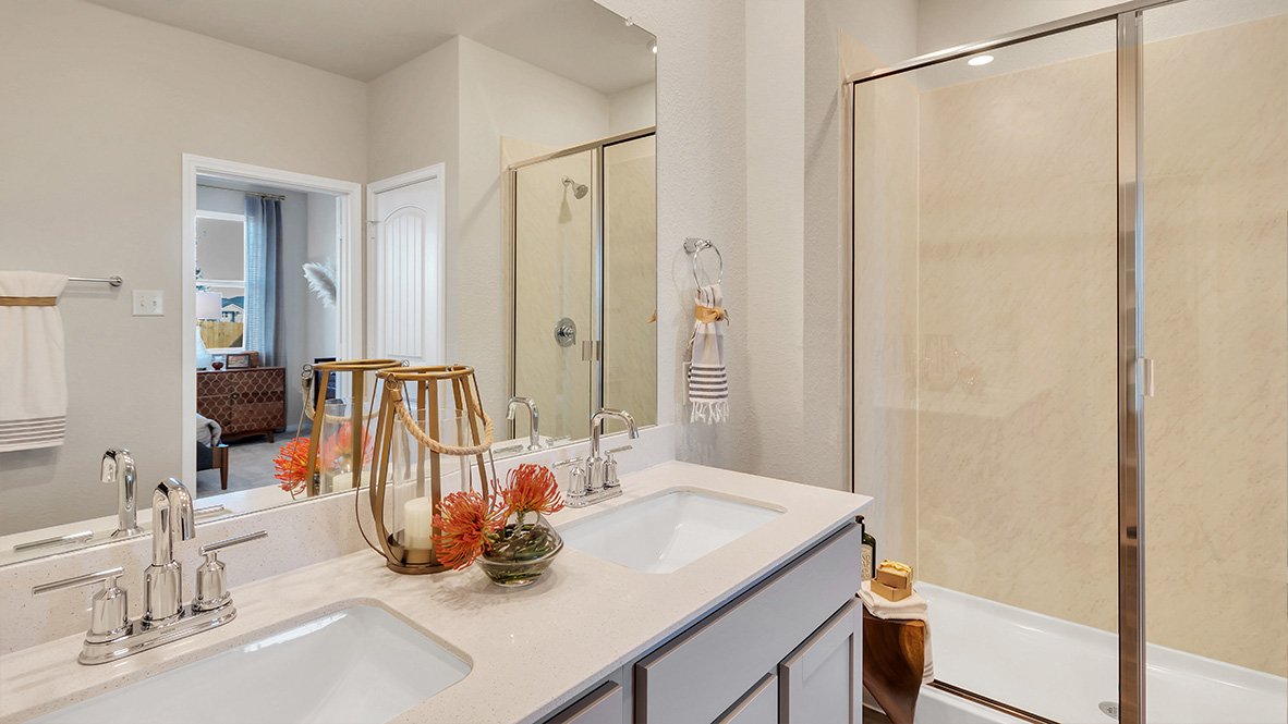 bathroom featuring dual vanity sinks, and a walk in shower