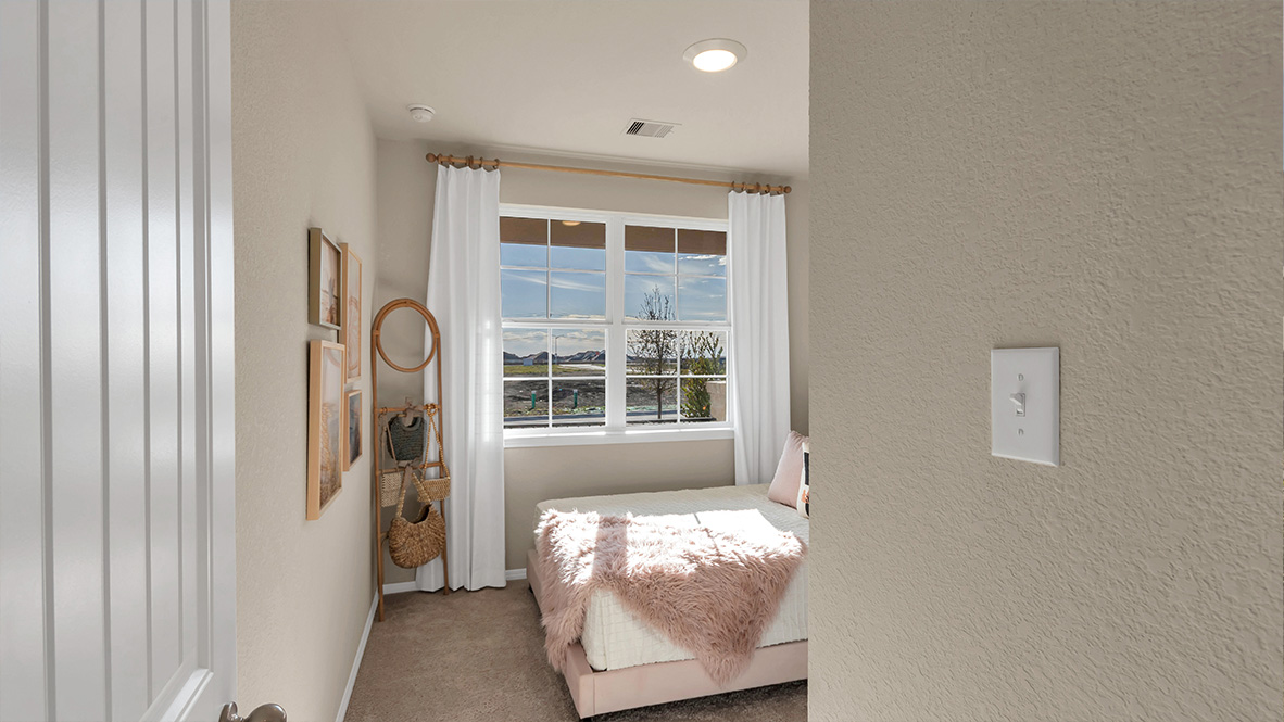 bedroom featuring a large window, a bed with [ink bedding and beige decor