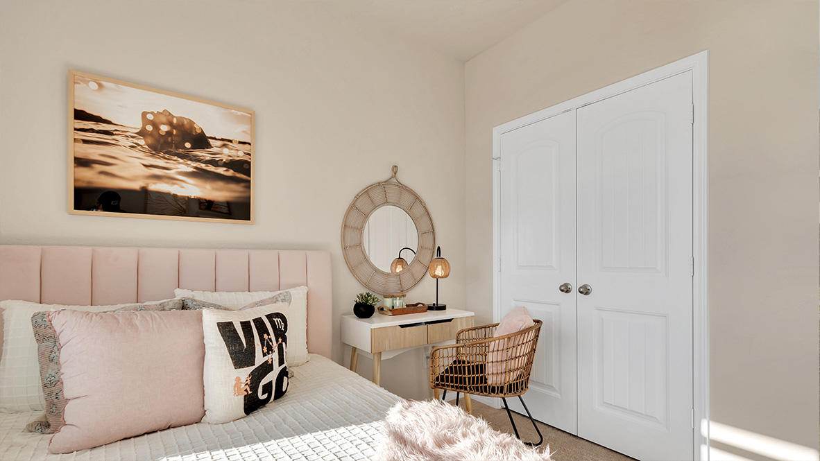 bedroom featuring a large window, a bed with [ink bedding and beige decor