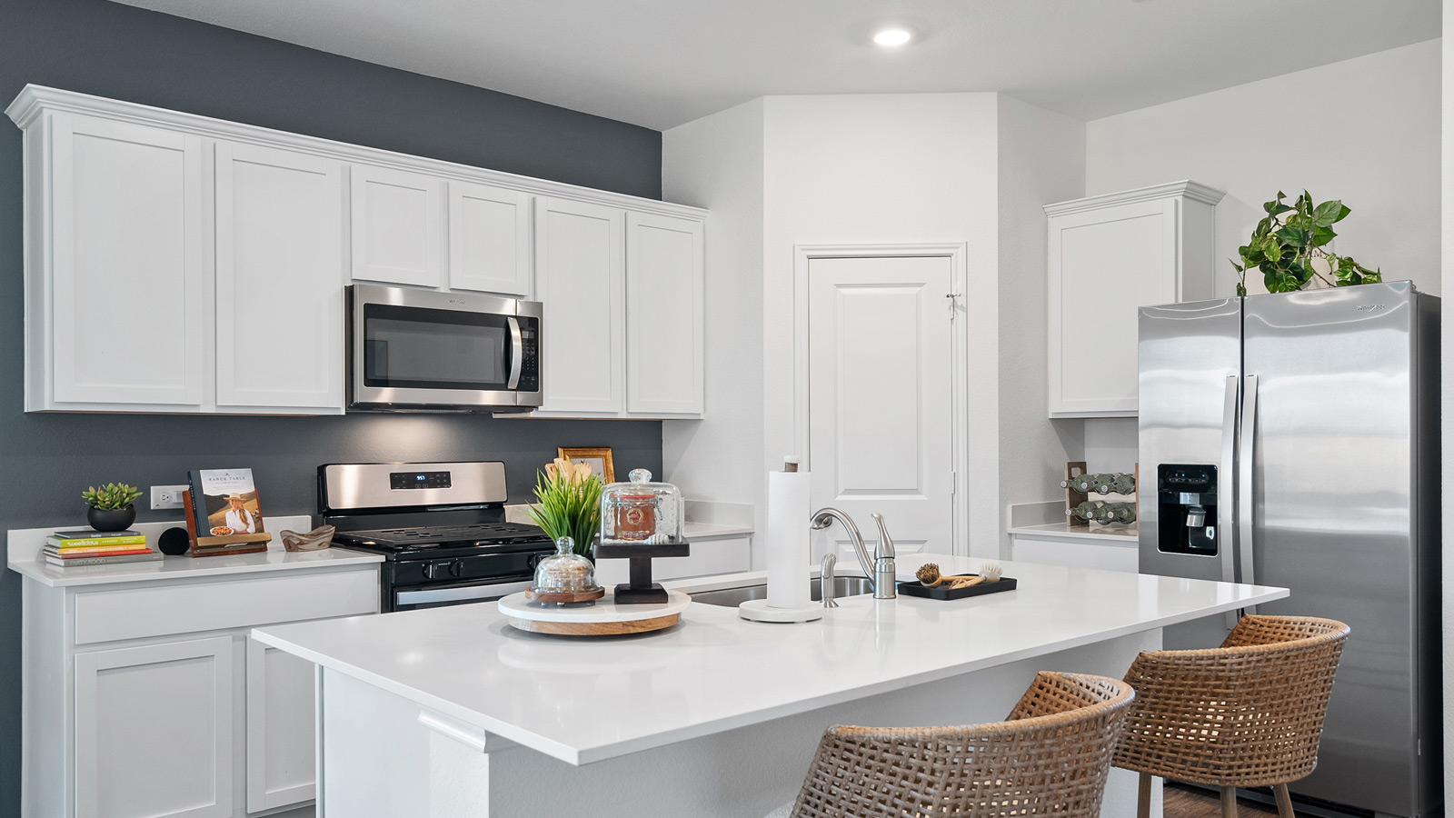 Kitchen with quartz countertops, stainless-steel appliances, and a walk-in pantry