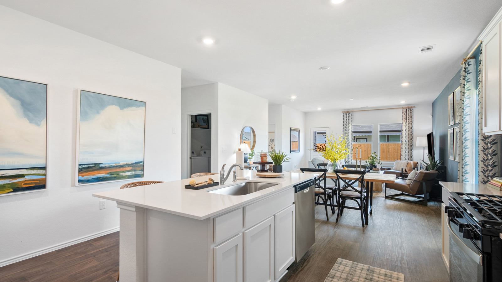 Kitchen with an island, a sink, and two paintings on the wall