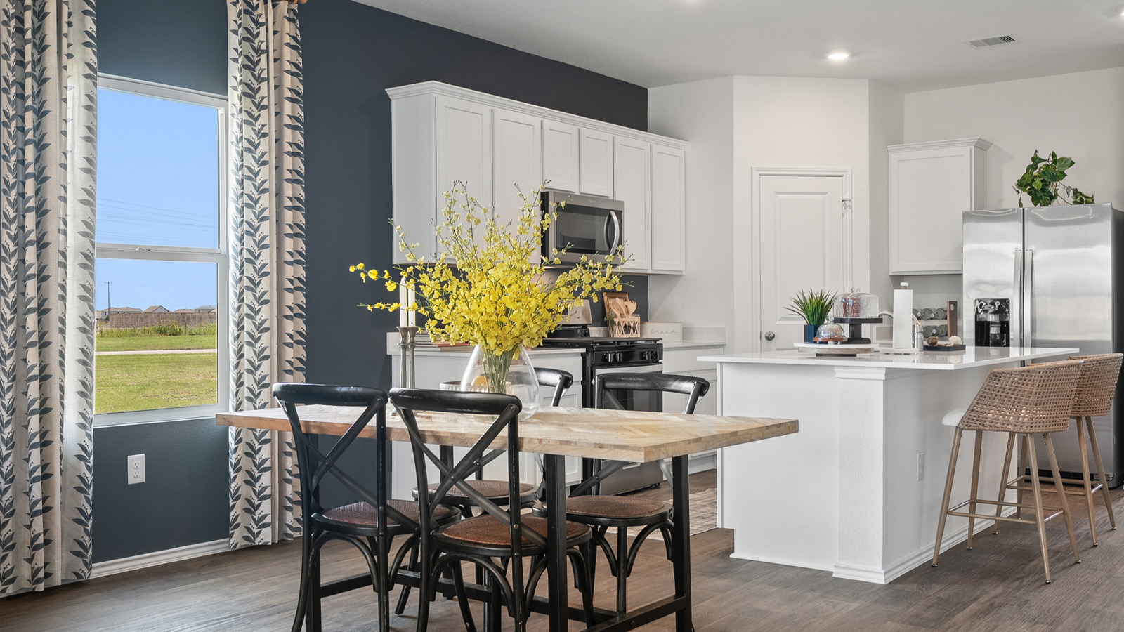 Open concept dining area with simple furnishings connecting to the kitchen.