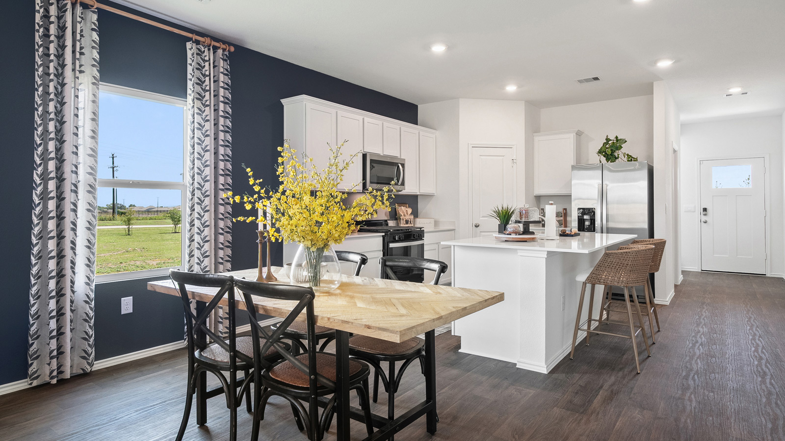 Open concept dining area with simple furnishings connecting to the kitchen.