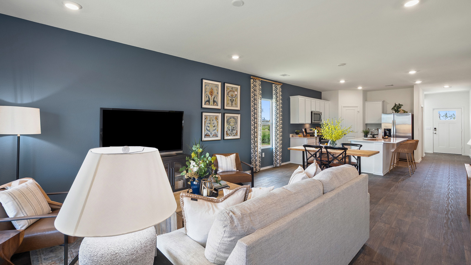 Bright open concept living space with overhead lighting and wood flooring