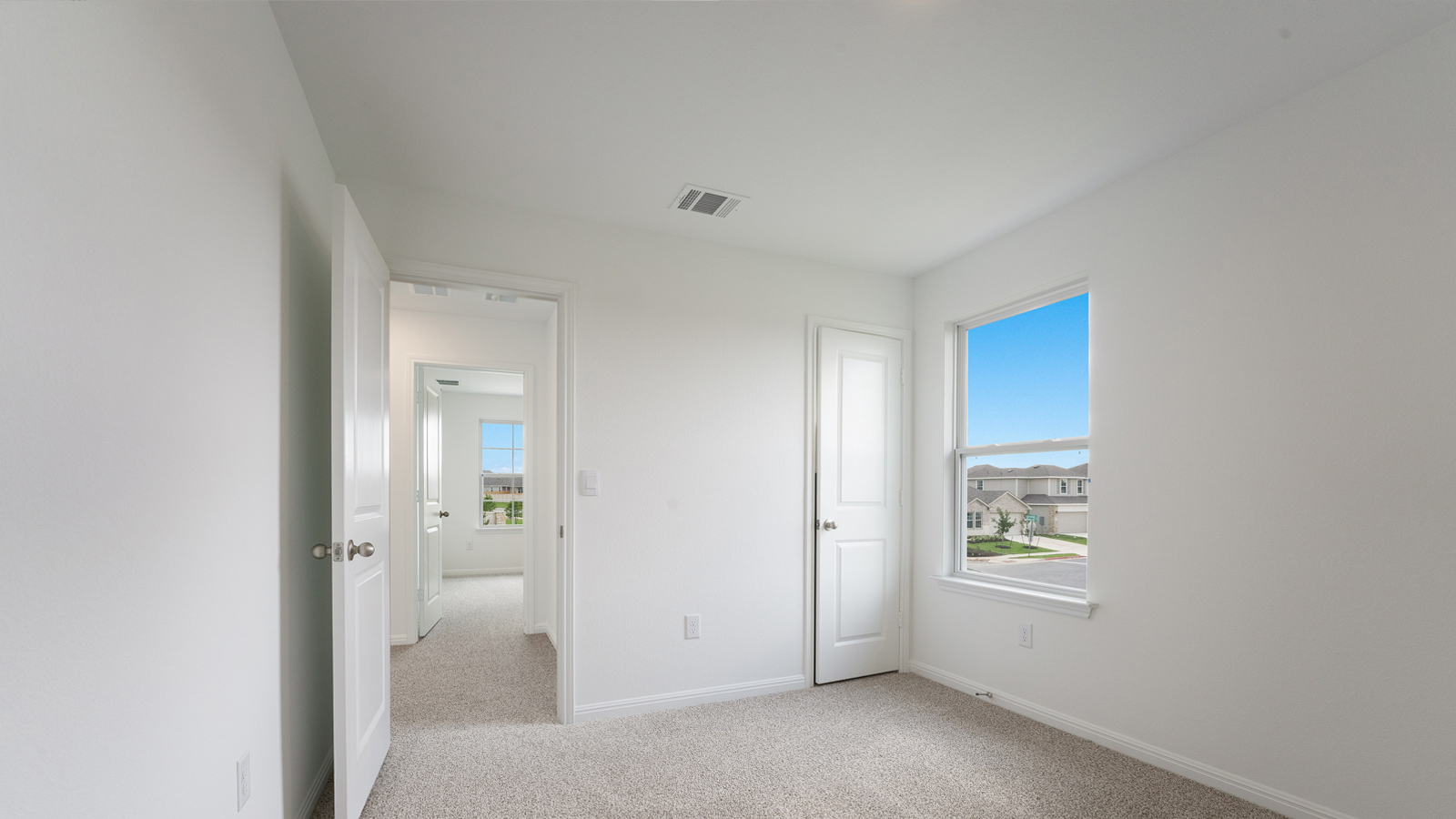 Bedroom 2 with carpeted floors and windows.