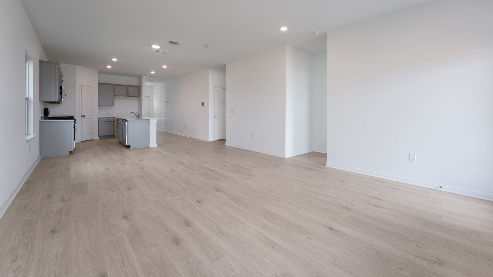 Spacious living room with wood look plank flooring.
