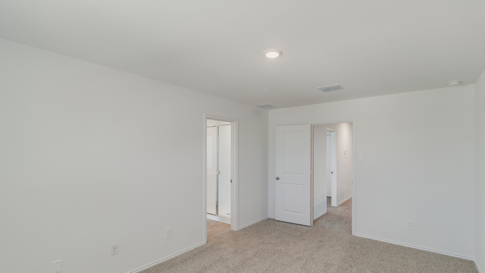 Primary bedroom with carpet, natural lighting, and a bathroom attached.