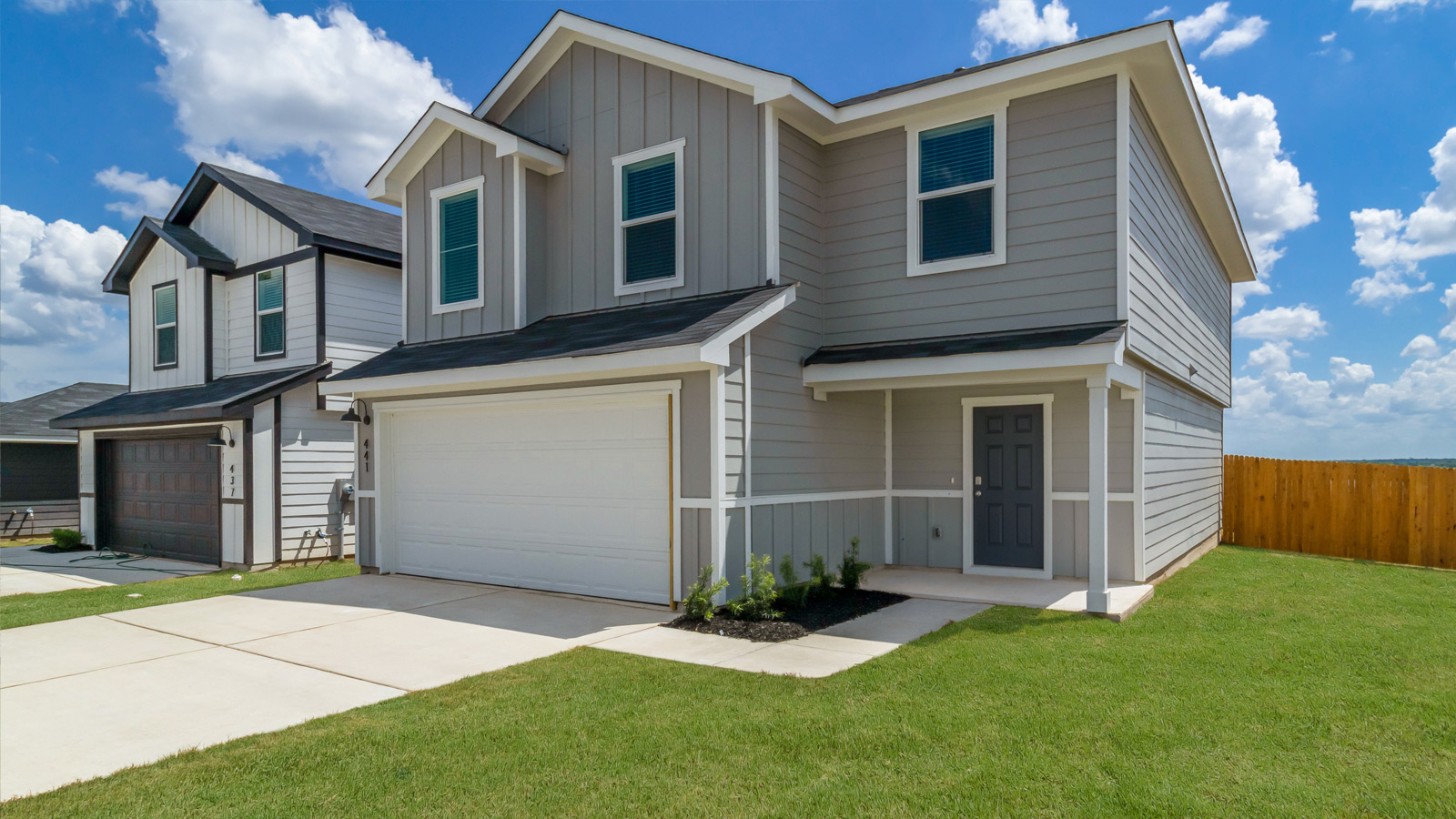 Two story home with attached garage and clean landscaping
