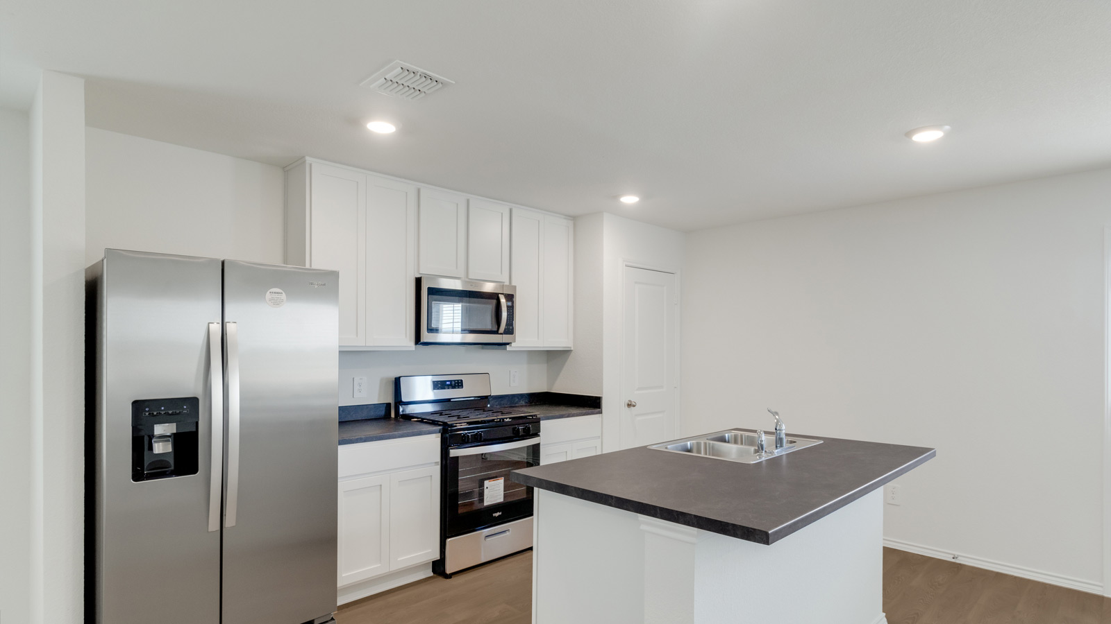 Kitchen featuring cabinets, new stainless steel appliances, and a large standing island.